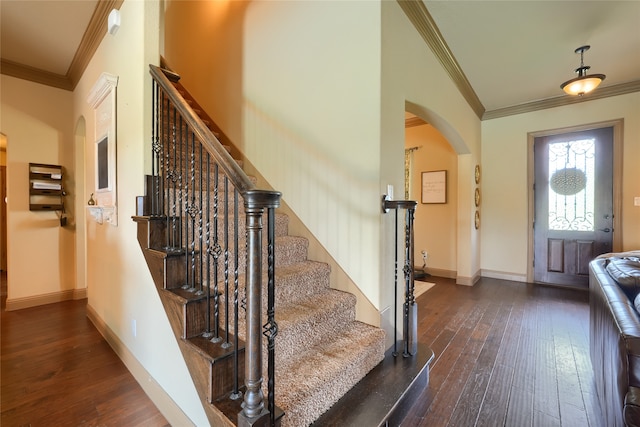 foyer entrance with ornamental molding and dark hardwood / wood-style flooring