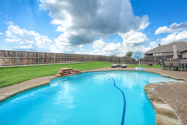 view of swimming pool with a yard