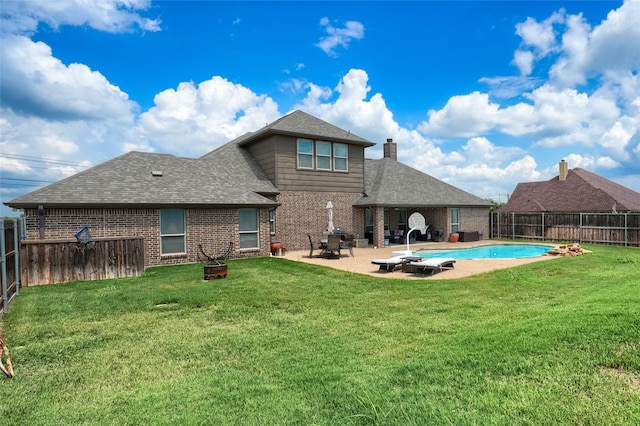 back of property featuring a lawn, a patio area, and a fenced in pool