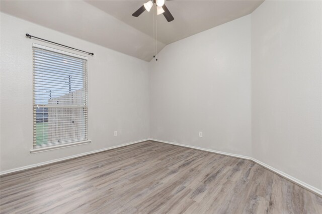 spare room featuring light wood-type flooring, ceiling fan, and lofted ceiling