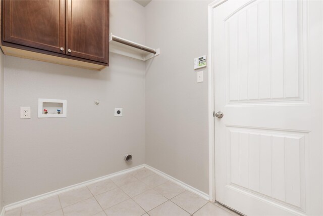 laundry area with hookup for a washing machine, cabinets, gas dryer hookup, light tile patterned floors, and hookup for an electric dryer