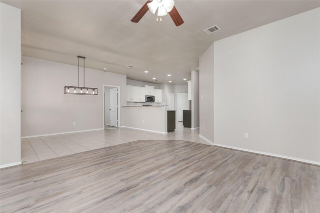 unfurnished living room featuring light hardwood / wood-style flooring and ceiling fan