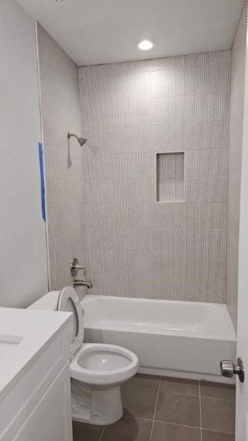 full bathroom featuring tile patterned floors, tiled shower / bath, toilet, and vanity