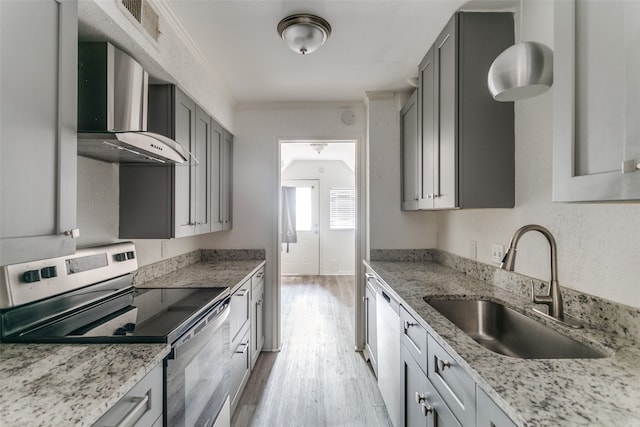 kitchen with gray cabinetry, light hardwood / wood-style floors, sink, wall chimney exhaust hood, and stainless steel range with electric cooktop