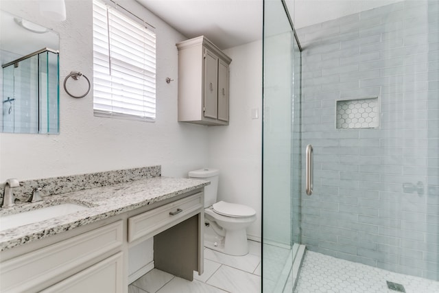 bathroom featuring vanity, toilet, and a shower with shower door