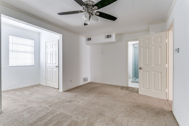 empty room with ceiling fan, crown molding, and light carpet