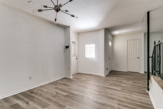 entrance foyer featuring crown molding and wood-type flooring