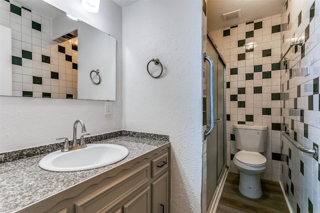2823 Summit View Dr, Bedford, TX 76021 - full bath with wood finished floors, a stall shower, tile walls, toilet, and visible vents