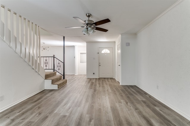 foyer entrance featuring crown molding, ceiling fan with notable chandelier, and hardwood / wood-style floors