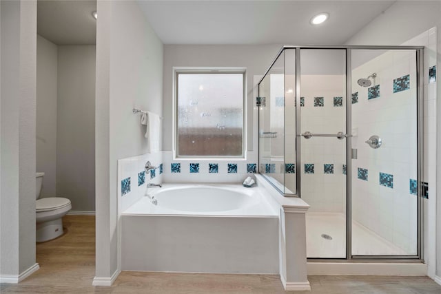 bathroom with toilet, hardwood / wood-style flooring, and plus walk in shower