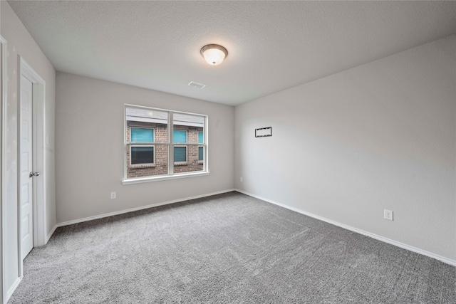 carpeted spare room with a textured ceiling