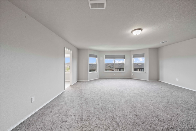 carpeted empty room featuring a textured ceiling