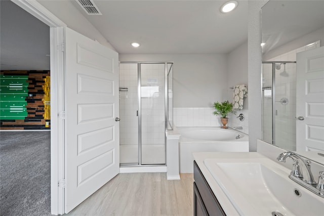 bathroom featuring vanity, wood-type flooring, and separate shower and tub