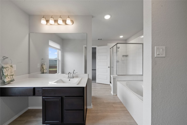 bathroom featuring vanity, hardwood / wood-style floors, and separate shower and tub