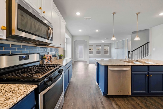 kitchen with blue cabinets, white cabinetry, stainless steel appliances, and dark hardwood / wood-style floors