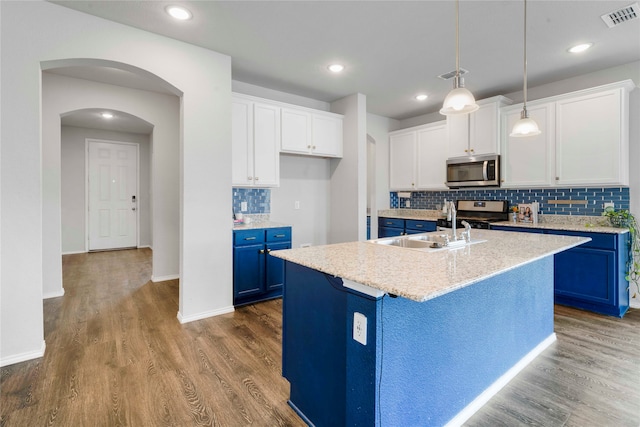 kitchen featuring blue cabinetry, appliances with stainless steel finishes, white cabinets, and an island with sink