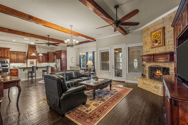 living room featuring dark hardwood / wood-style floors, beamed ceiling, a stone fireplace, ornamental molding, and ceiling fan with notable chandelier