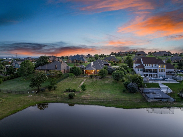 aerial view at dusk featuring a water view