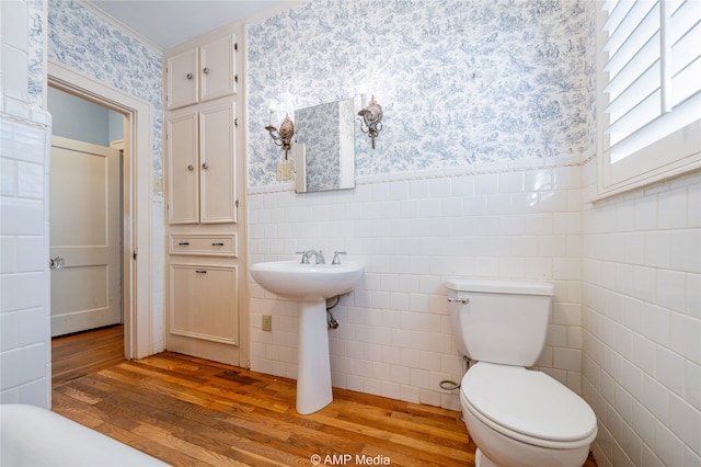 bathroom with tile walls, toilet, and hardwood / wood-style flooring