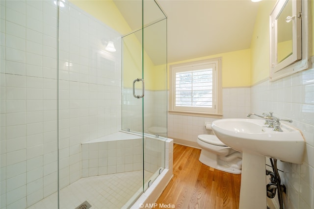 bathroom featuring toilet, an enclosed shower, vaulted ceiling, tile walls, and hardwood / wood-style flooring