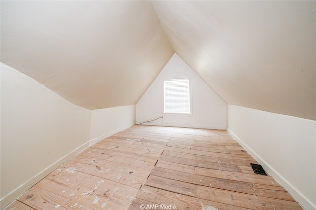 additional living space featuring lofted ceiling and light hardwood / wood-style flooring