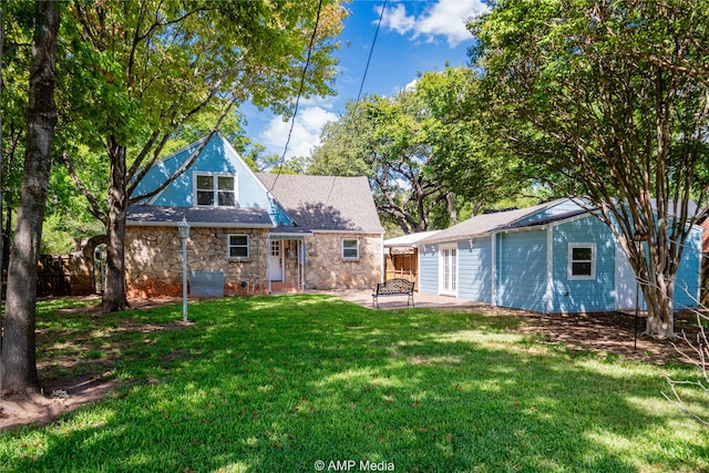 rear view of house with a yard and a patio