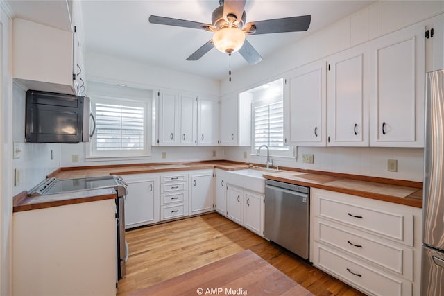 kitchen featuring ceiling fan, stainless steel appliances, white cabinetry, and a healthy amount of sunlight