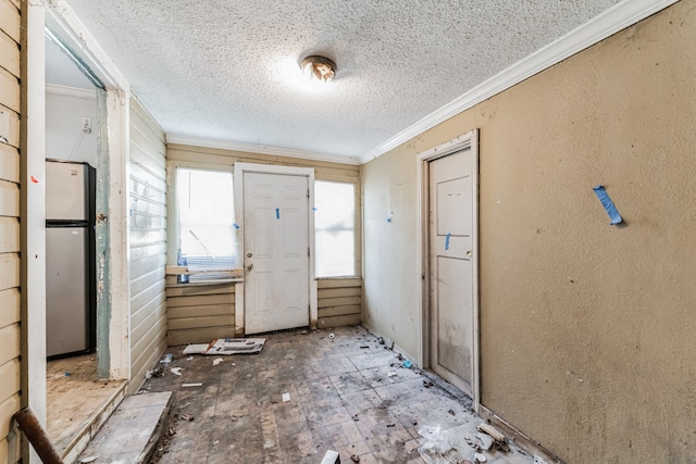 interior space featuring a textured ceiling and ornamental molding