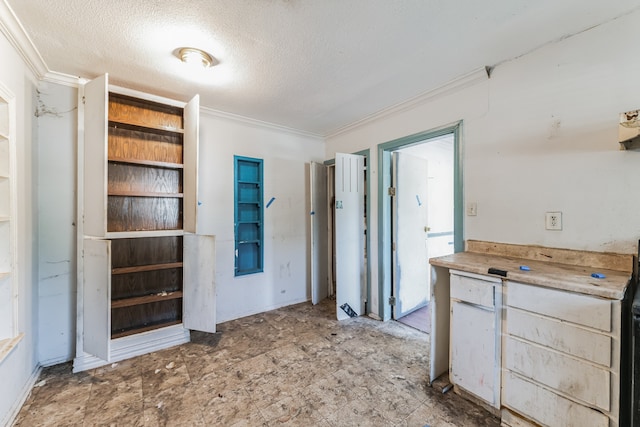 kitchen with a textured ceiling and crown molding