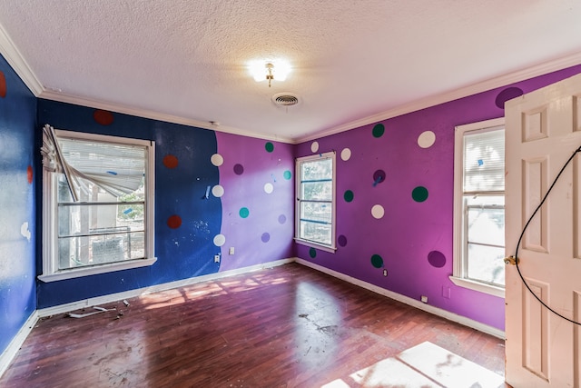 spare room with crown molding, plenty of natural light, and wood-type flooring