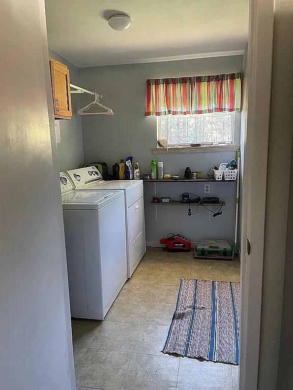 clothes washing area with cabinets and separate washer and dryer