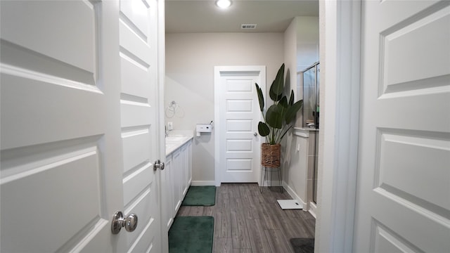 bathroom featuring vanity, wood-type flooring, and walk in shower