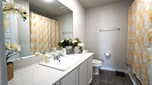 bathroom featuring vanity, toilet, and hardwood / wood-style flooring