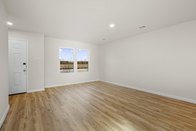 empty room with light hardwood / wood-style flooring