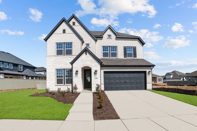 view of front of home with a garage and a front lawn