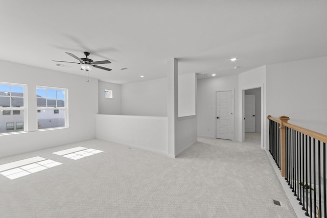 unfurnished room with light colored carpet and ceiling fan