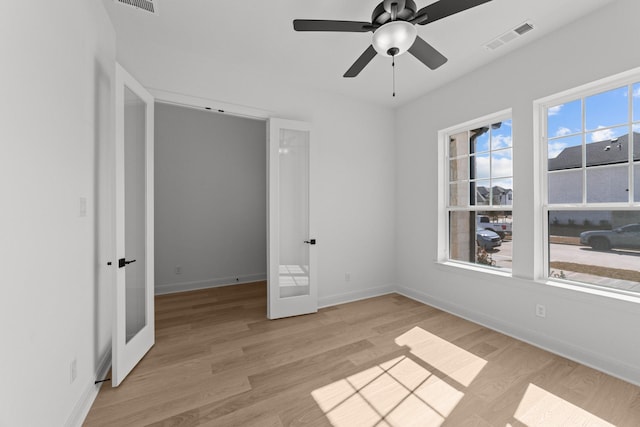 unfurnished bedroom featuring light hardwood / wood-style floors, french doors, and ceiling fan