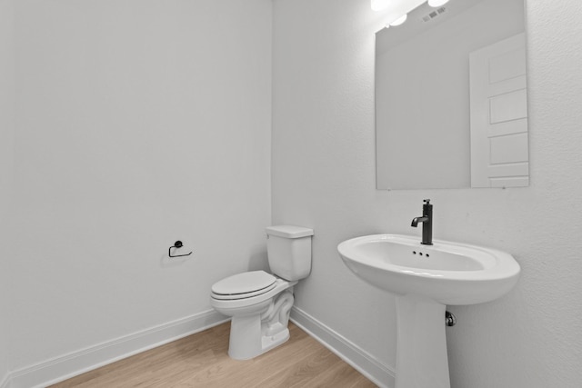 bathroom with wood-type flooring and toilet