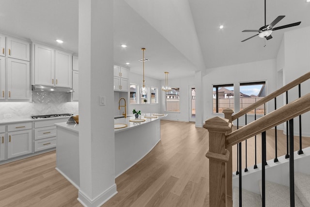 kitchen featuring a healthy amount of sunlight, decorative light fixtures, white cabinets, and light wood-type flooring