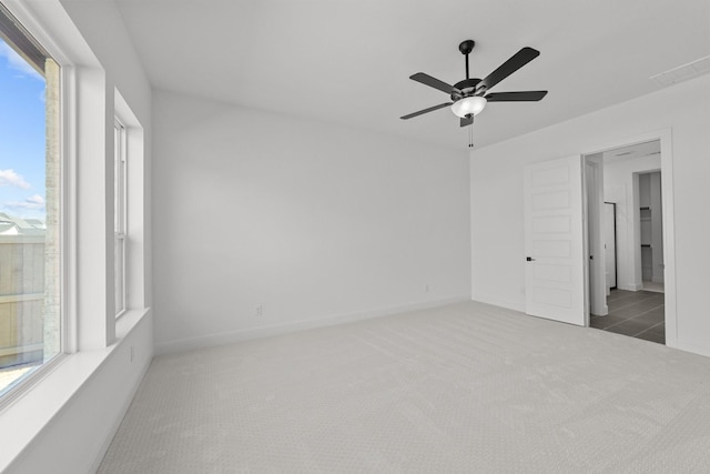 empty room with ceiling fan and dark carpet