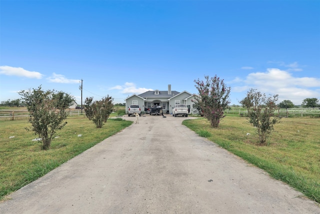 view of front of property with a front lawn and a rural view