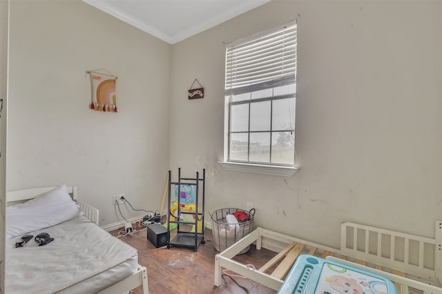 bedroom with ornamental molding and wood-type flooring