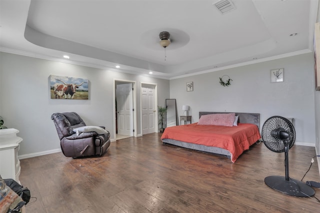 bedroom with crown molding, a raised ceiling, ceiling fan, and dark hardwood / wood-style floors