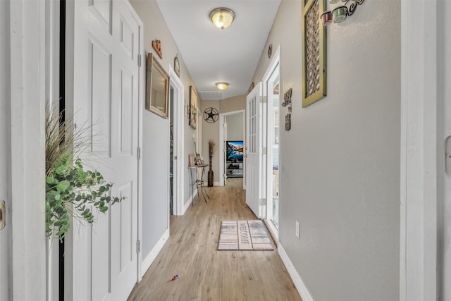 hallway with plenty of natural light and light hardwood / wood-style floors