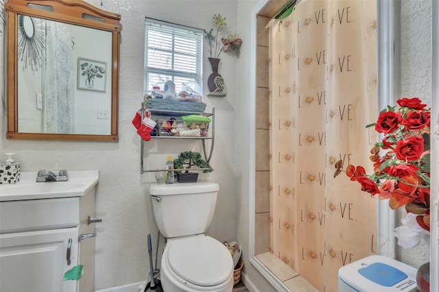 bathroom with curtained shower, toilet, and vanity