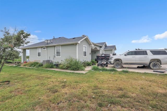 view of side of home featuring a lawn and central AC unit