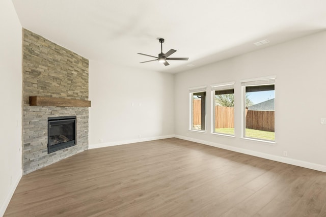 2617 Lila St, Burleson, TX 76028 - unfurnished living room with ceiling fan, wood finished floors, baseboards, and a stone fireplace