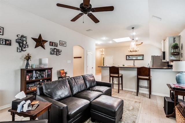 5204 Balsam Dr, Mckinney, TX 75071 - living area with arched walkways, visible vents, light wood-type flooring, and a ceiling fan