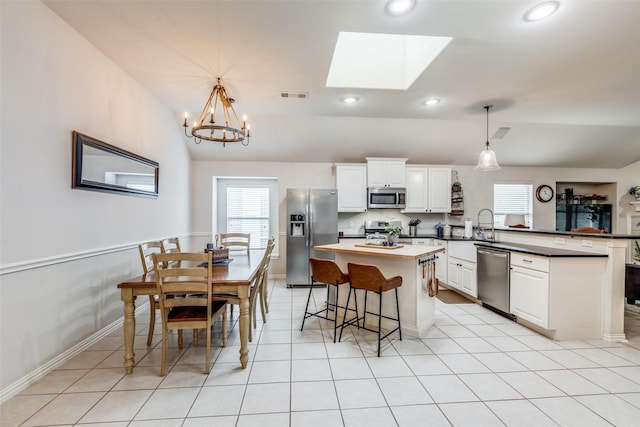 5204 Balsam Dr, Mckinney, TX 75071 - kitchen with white cabinetry, stainless steel appliances, a kitchen island, visible vents, and a peninsula