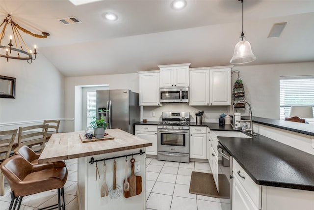 5204 Balsam Dr, Mckinney, TX 75071 - kitchen featuring visible vents, a peninsula, stainless steel appliances, a sink, and light tile patterned floors
